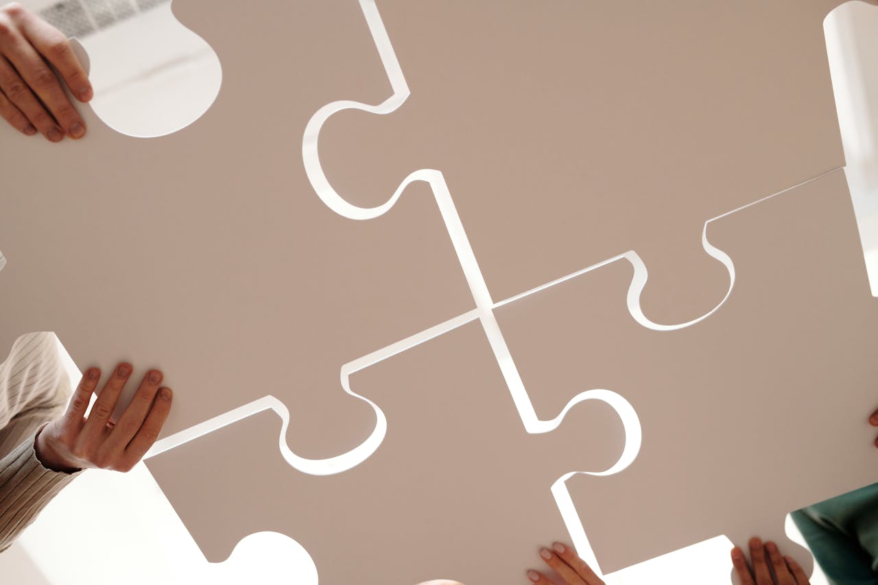Ludzie trzymający duże elementy układanki symbolizujące integrację systemów jak Google Tag Manager