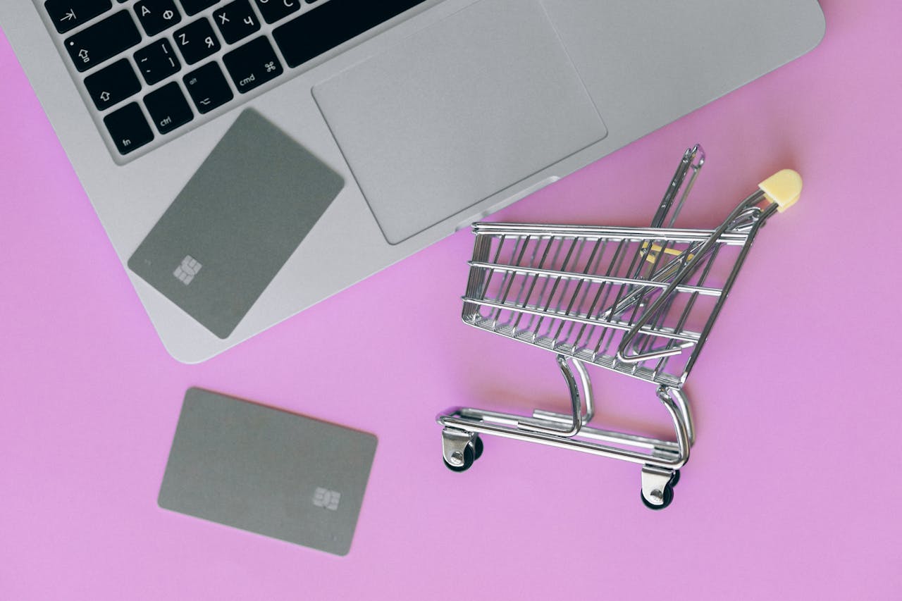 Zapamiętywanie koszyków – zakupy online z kartą płatniczą i mini wózkiem obok laptopa