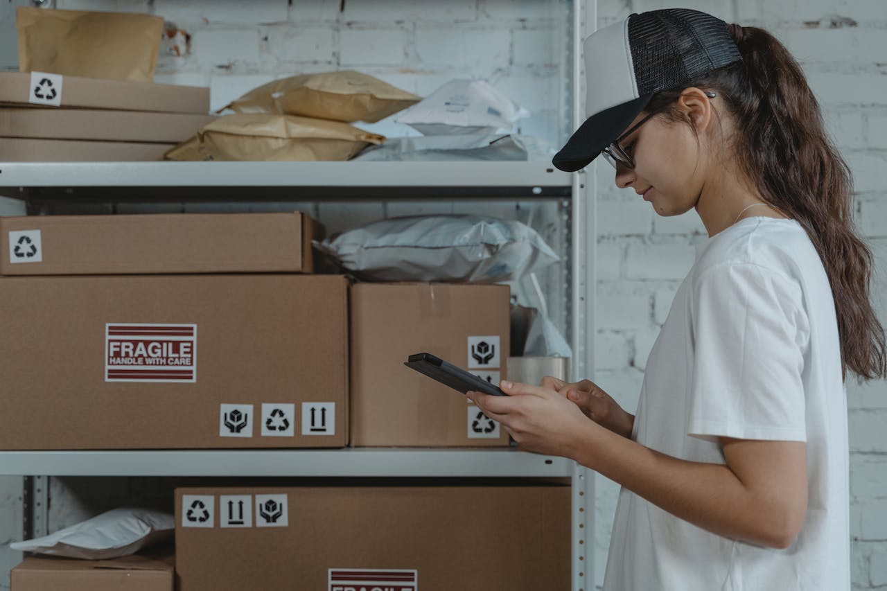 Pracowniczka magazynu zarządzająca paczkami za pomocą tabletu – ilustracja logistyki i zarządzania zamówieniami z wykorzystaniem Dynamics 365 Business Central.