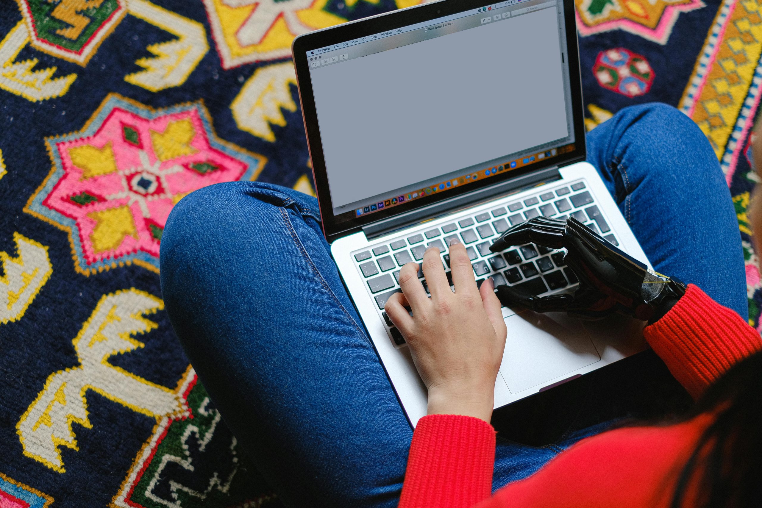 a person sitting on the floor using a laptop